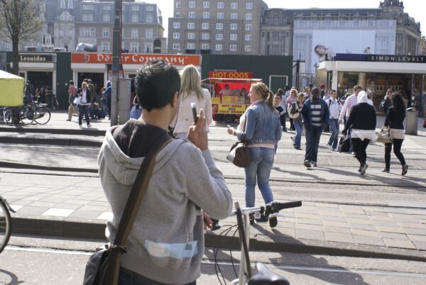 Jongen wacht vriendin bij Centraal Station, omhelzing volgt.