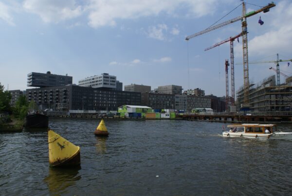 Bouw IJdock Amsterdam, gele boeien in water.