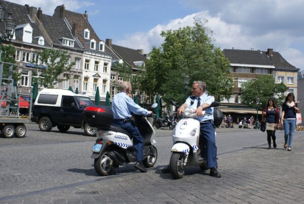 Dienst Handhaving Maastricht op scooter op de Markt.