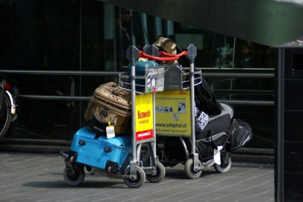 Reizigers met koffers op Schiphol.