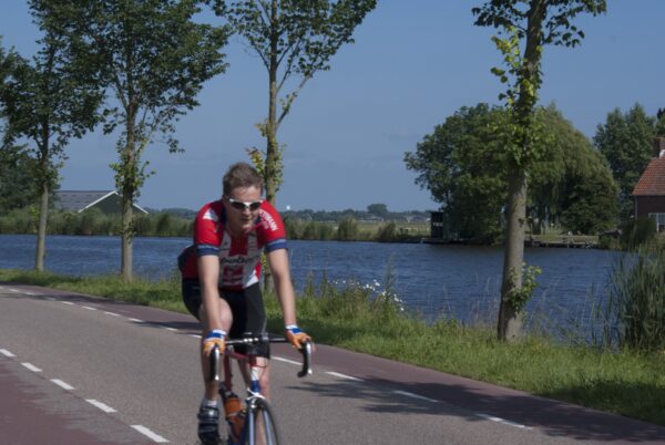 Fietser op Amsteldijk langs de Amstel.