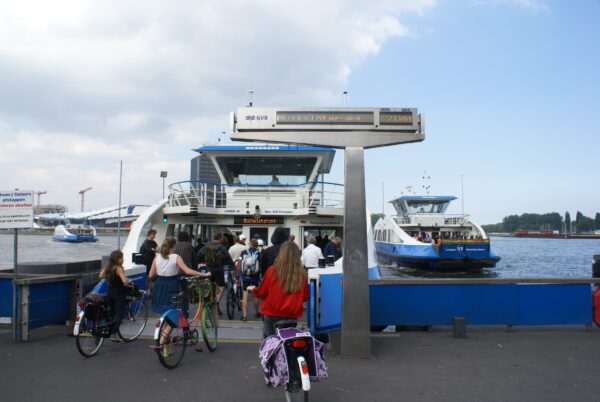 Fietser stapt op veerpont Buiksloterweg, Amsterdam Noord.