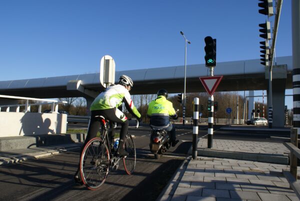 Fietsers wachten bij stoplicht, Schiphol Oost.