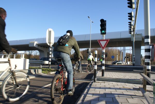 Fietsers wachten bij stoplicht, Schiphol Oost.