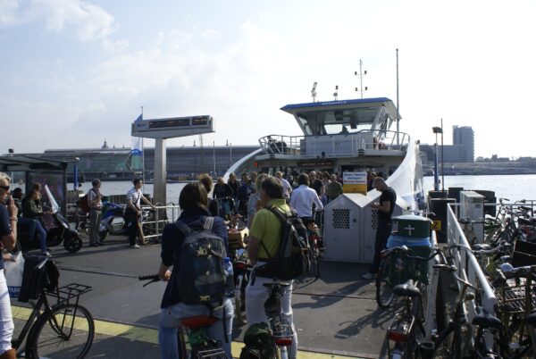 Fietsers wachten veerpont IJ, Amsterdam Noord.