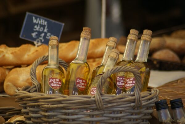 Olijfolie flesjes en brood op marktkraam.