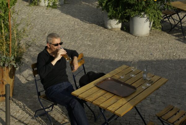 Man drinkt bier in de zon aan de Spree.
