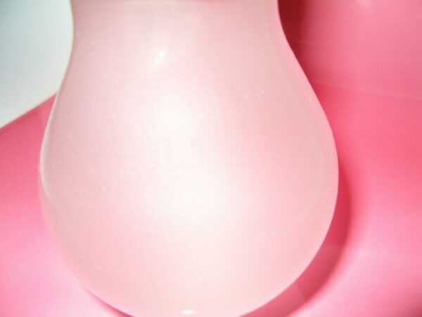 Gloeilamp sculptuur van papier op roze/witte achtergrond.