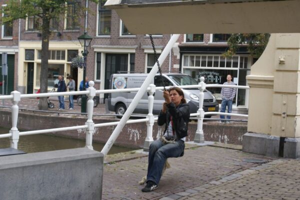Brug wordt omhoog gesjord door brugwachtster.