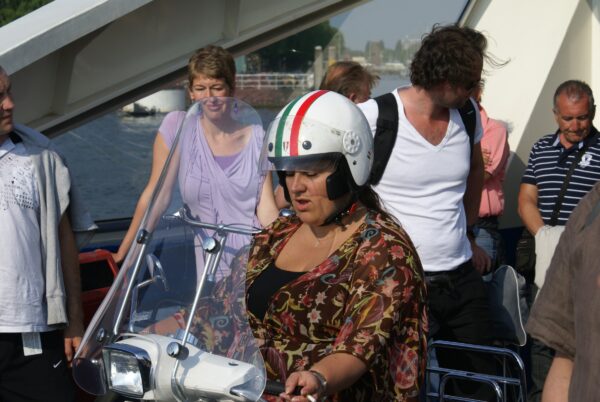 Vrouw belt handsfree op scooter.