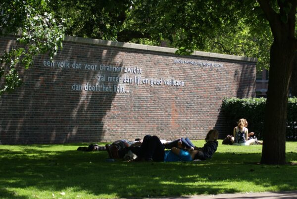 Randwijkmonument in Amsterdam, mensen ontspannen in het gras.