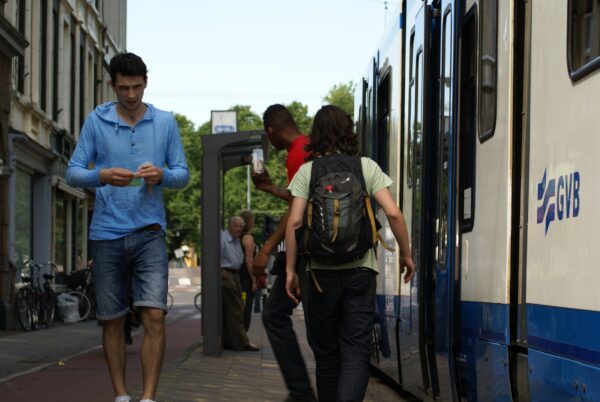 Jonge man rolt shag bij tramhalte Stadhouderskade.