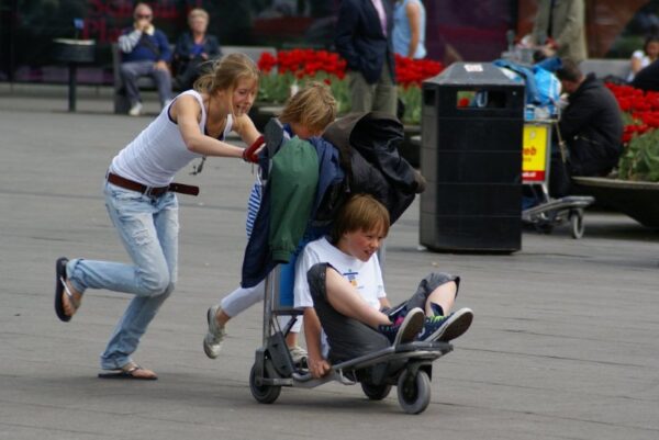 Kinderen rennen op bagagewagen Schiphol.