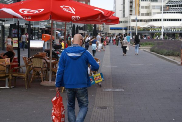 Man met kassabon en groot pak vaatwasmiddel.