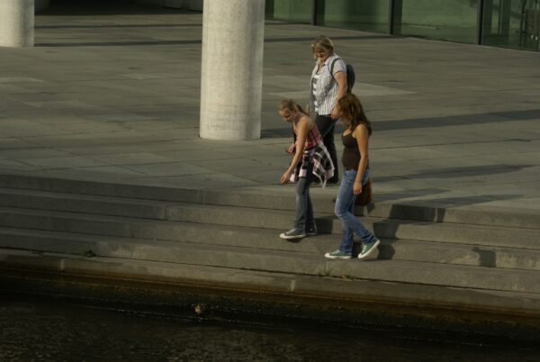 Drie vrouwen voeren eendjes langs de Spree.