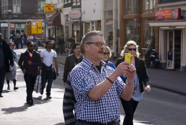 Babyboomer fotografeert met gele iPhone.