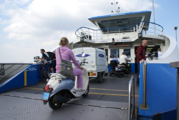Meisje op scooter op GVB-veerpont.