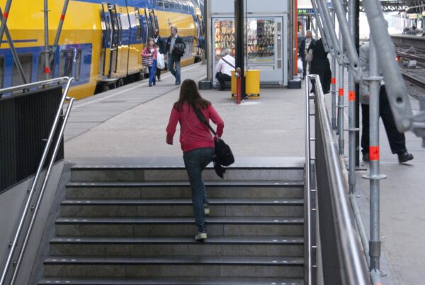 Meisje rent trap Centraal Station, Amsterdam.