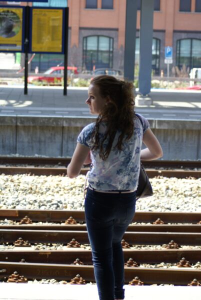 Meisje wacht bij treinstation.