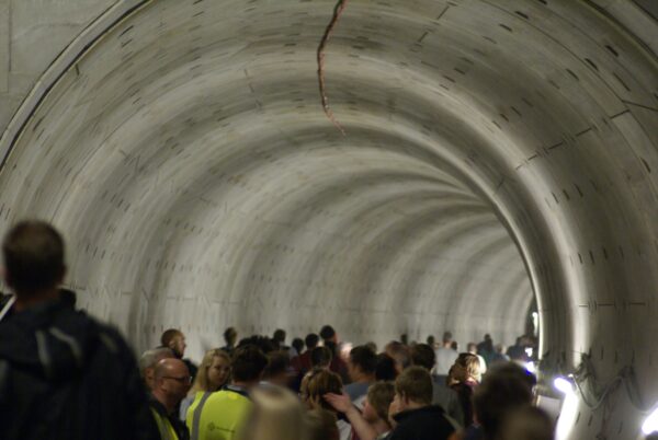 Mensen wachten bij tunnelbuis Amsterdam Centraal.