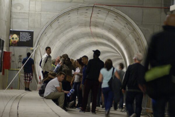 Groep wacht bij tunnelbuis Amsterdam Centraal.
