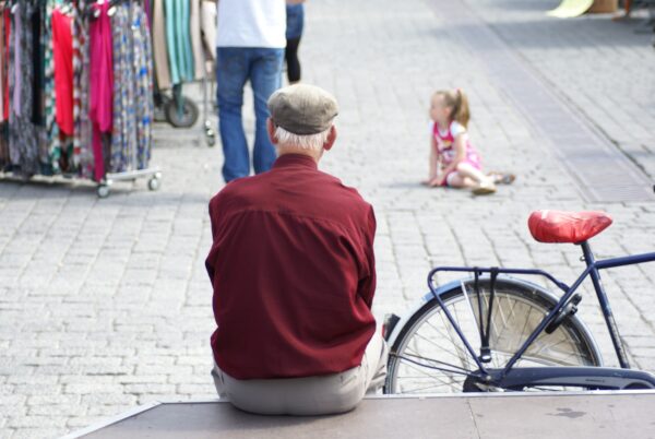 Oude man kijkt naar meisje op Markt Den Bosch.