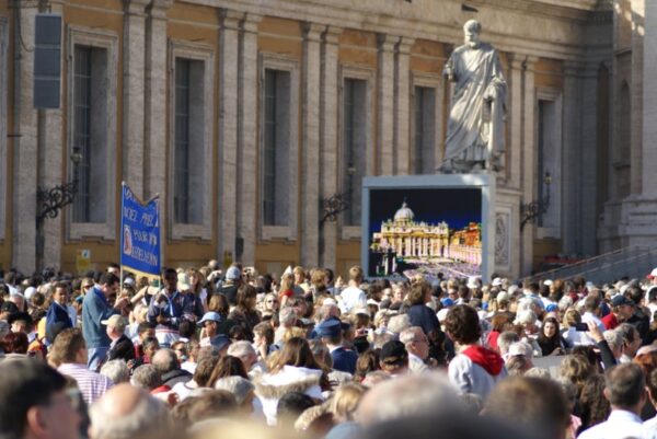 Paus omringd door enthousiaste fans en hinderlijke toeschouwers.
