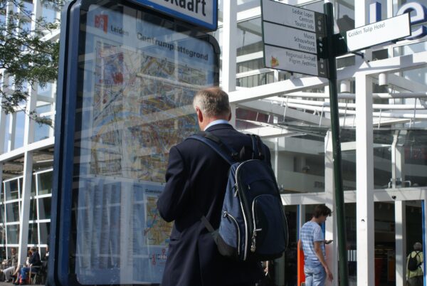 Man bekijkt plattegrond NS station Leiden.