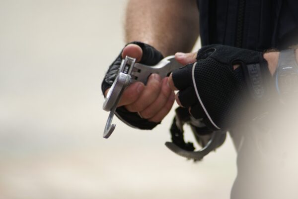 Politie doet handboeien om arrestant, demonstratie Flikkendag 2014.