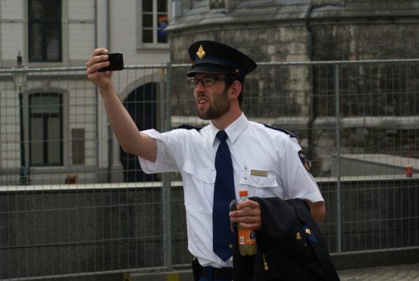 Politieagent in oud uniform maakt selfie (2014).