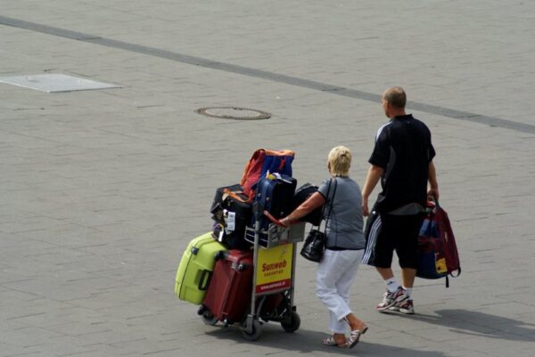Reizigers met koffers op Schiphol.