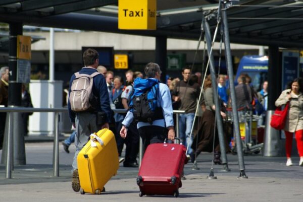 Reizigers met koffers op Schiphol.