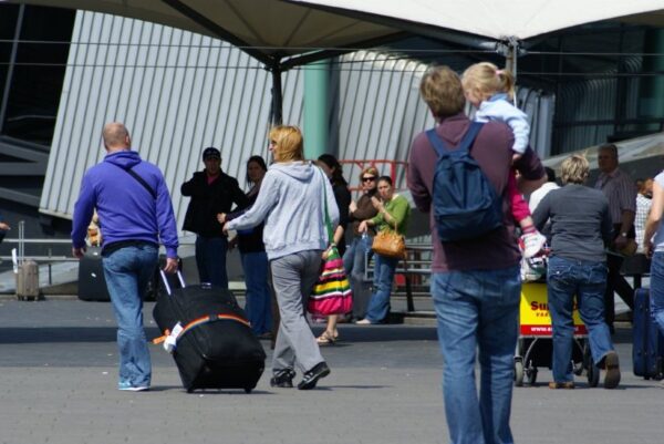 Reizigers met koffers op Schiphol.