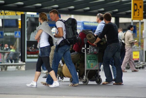 Reizigers met koffers op Schiphol.