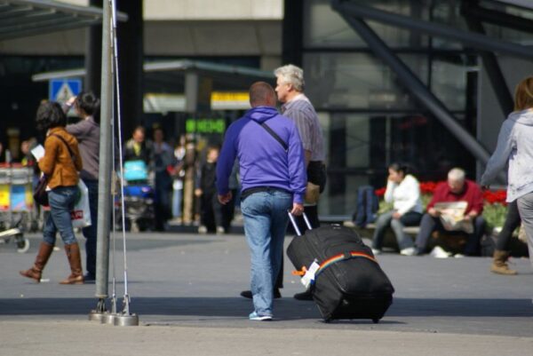 Reizigers met koffers op Schiphol.