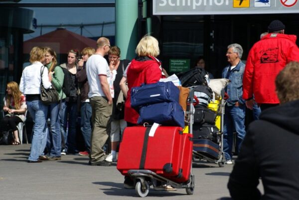 Reizigers met koffers op Schiphol.