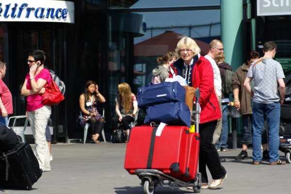 Reizigers met koffers op Schiphol.