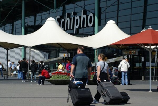 Reizigers met koffers op Schiphol.