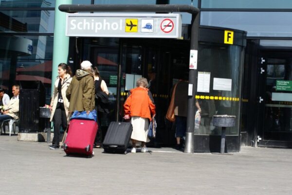 Reizigers met koffers op Schiphol.