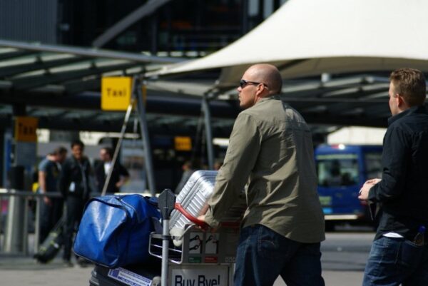 Reizigers met koffers op Schiphol.