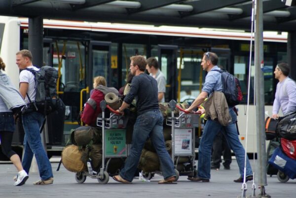 Reizigers met koffers op Schiphol.