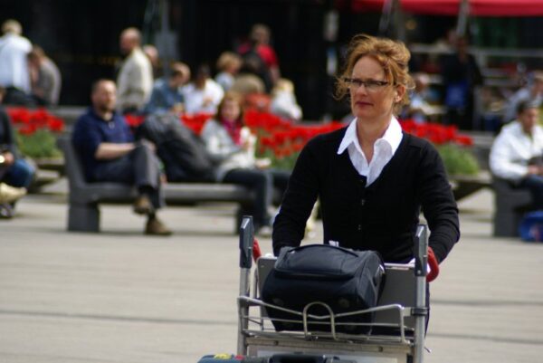 Reizigers met koffers op Schiphol.