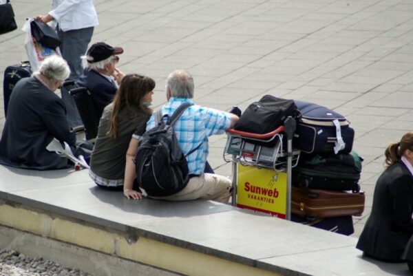 Reizigers met koffers op Schiphol.