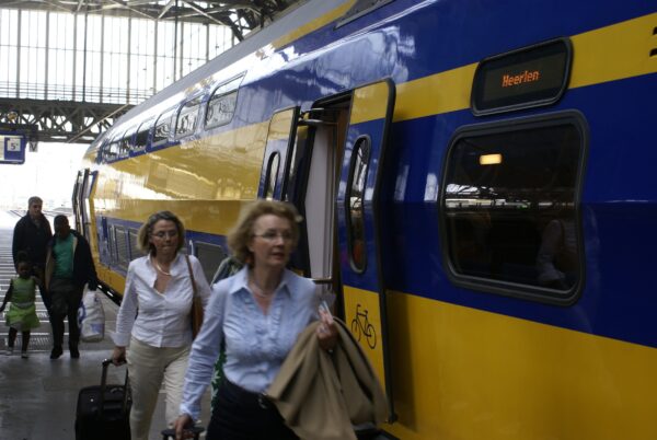 Reizigers stappen in trein naar Maastricht, Amsterdam Centraal.