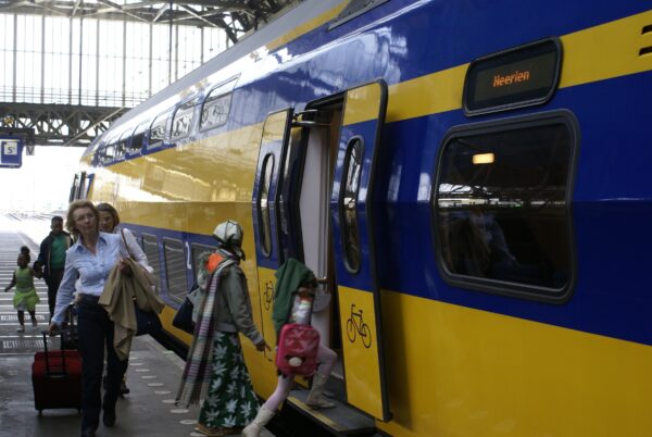Reizigers stappen in trein naar Maastricht, Amsterdam Centraal.