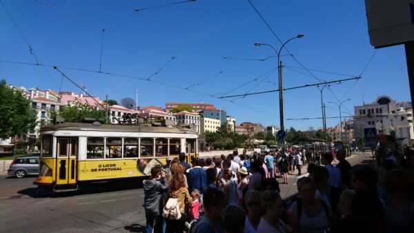 Lange rij wachtend bij kleine tram.