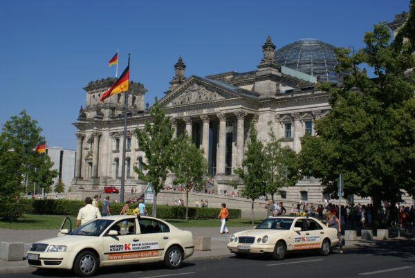 Rijksdag met taxi's voor de deur.
