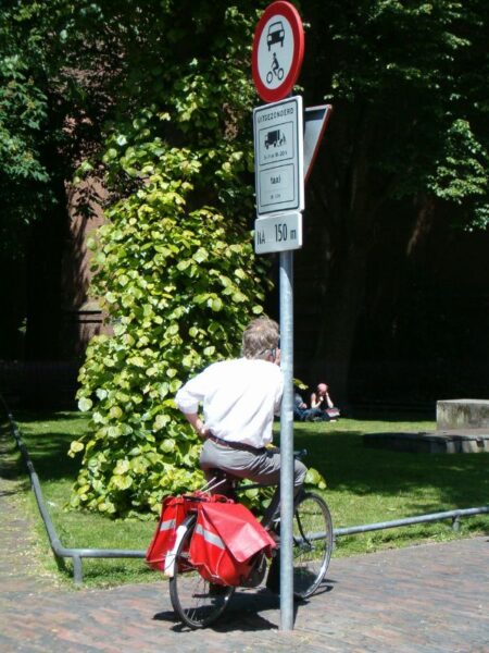 Persoon rust uit tegen verkeersbord.