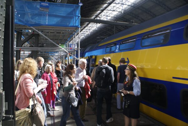 Mensen bij trein naar Alkmaar, vraag aan conducteur.