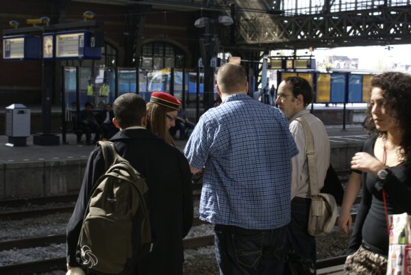 Reizigers vragen NS-conductrice om info.